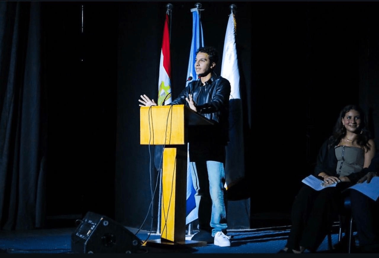 A delegate speaking at the yellow lectern in front of the Egyptian, UN and conference flags